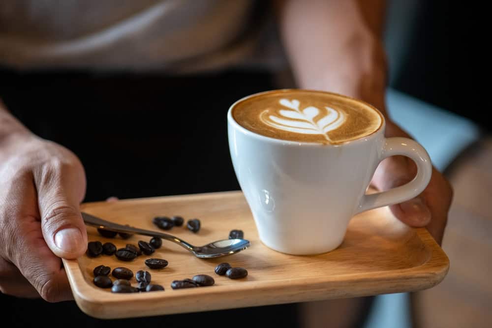 A barista serves a latte at a café in Nonthaburi