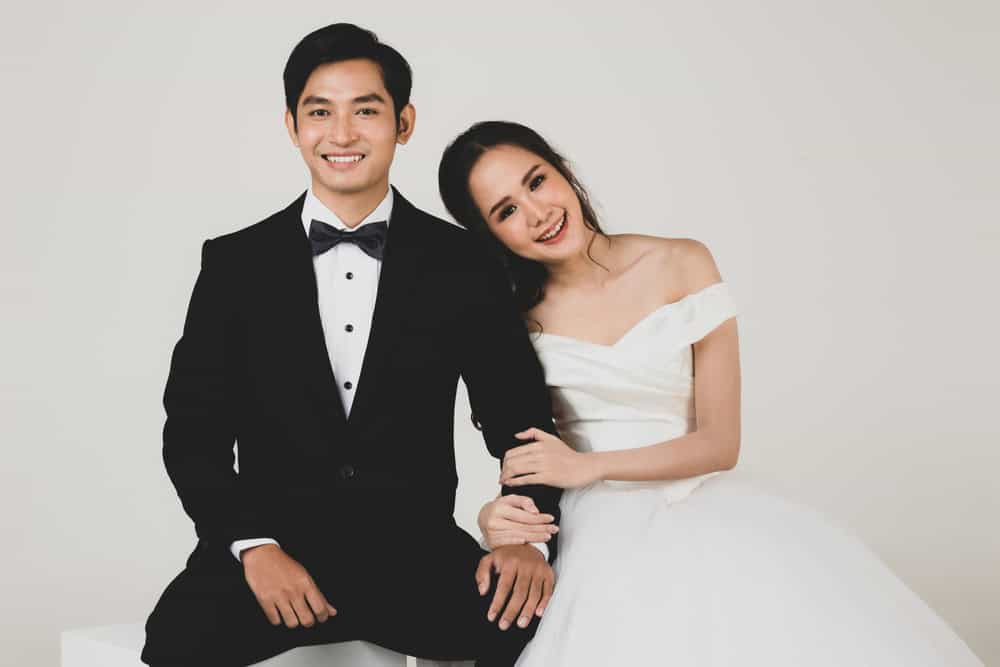 A couple poses for a photograph at their wedding venue