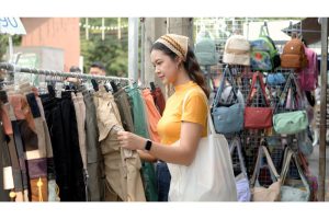 ผู้หญิงเลือกซื้อของที่ตลาดขายของมือสองในนนทบุรี