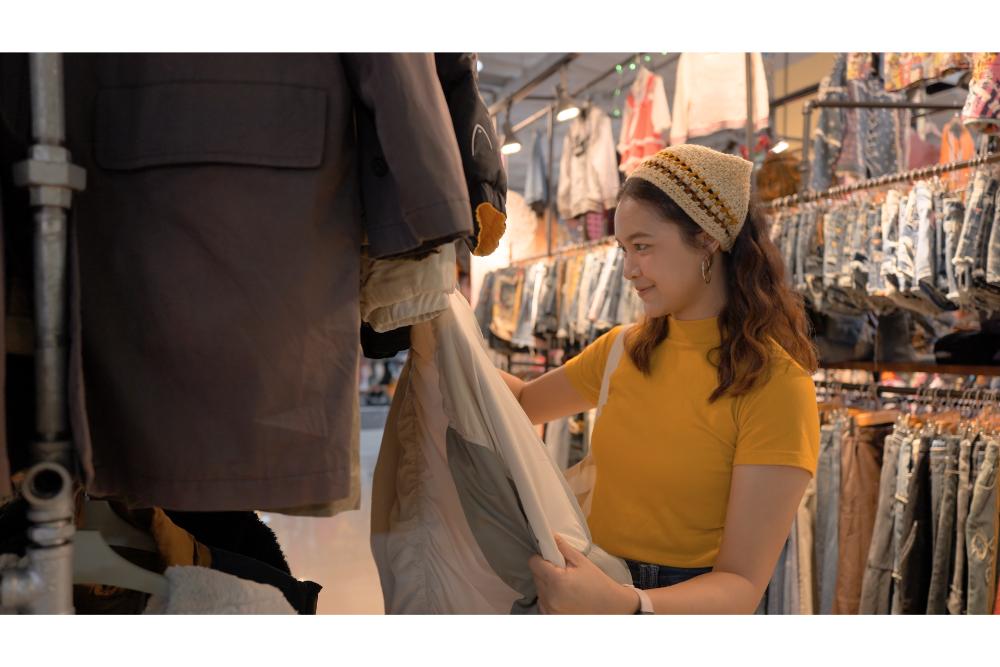 ผู้หญิงเลือกเสื้อผ้ามือสองที่ตลาดมือสองในนนทบุรี