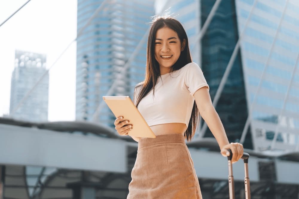 A female staff member out with her luggage for a company outing trip in Bangkok.